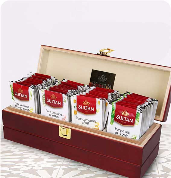 Wooden box filled with Sultan Tea packets on a patterned table